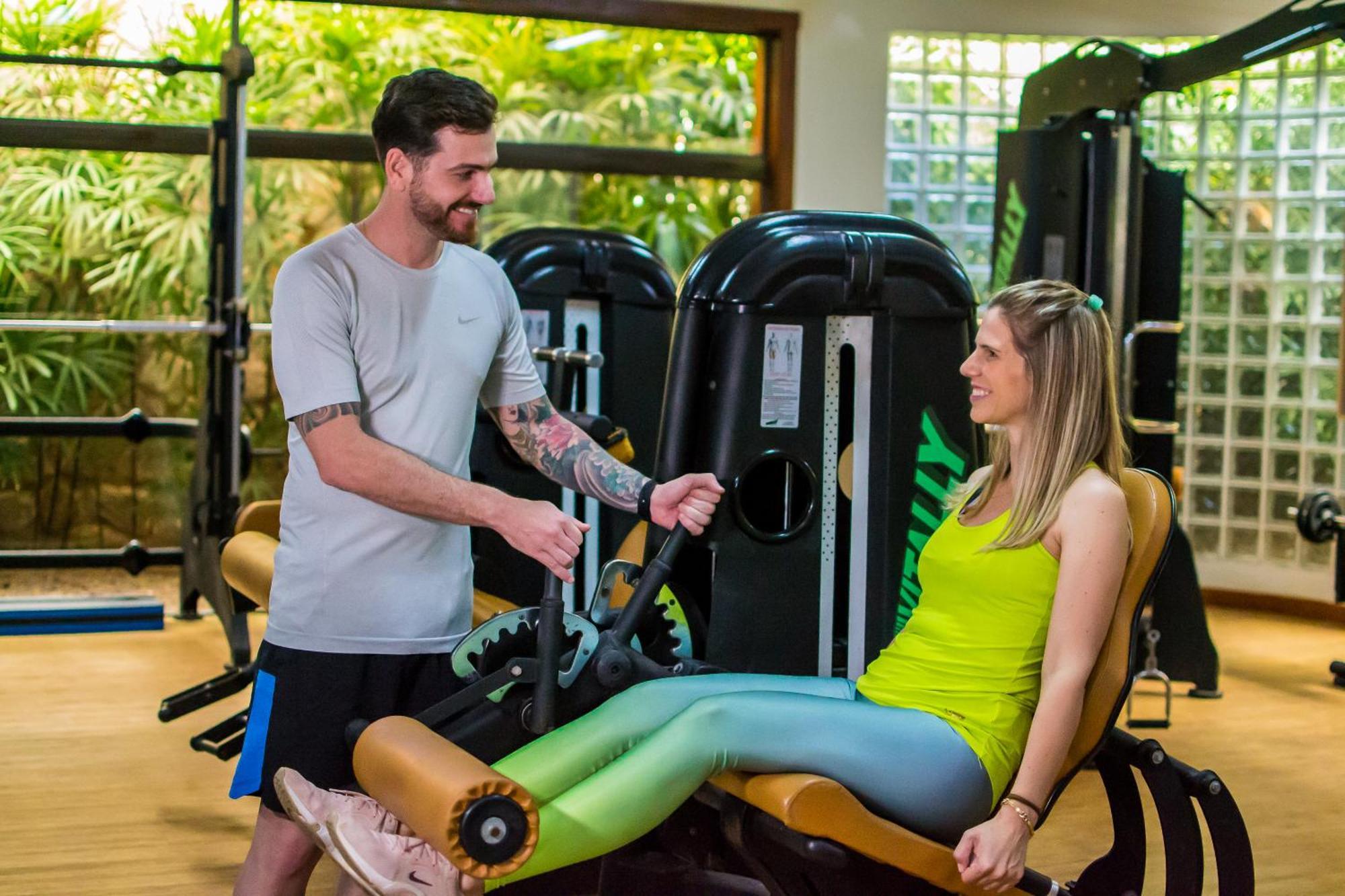 Blue Tree Thermas De Lins Resort Exteriér fotografie Personal trainer assisting a woman on a leg press machine